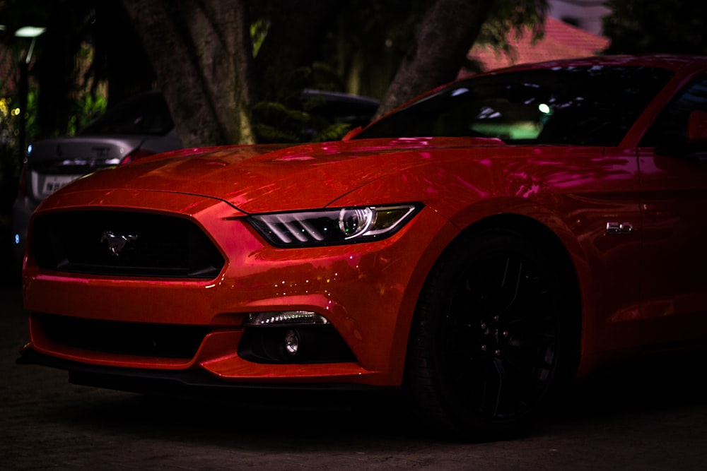 red Ford Mustang coupe parking near tree