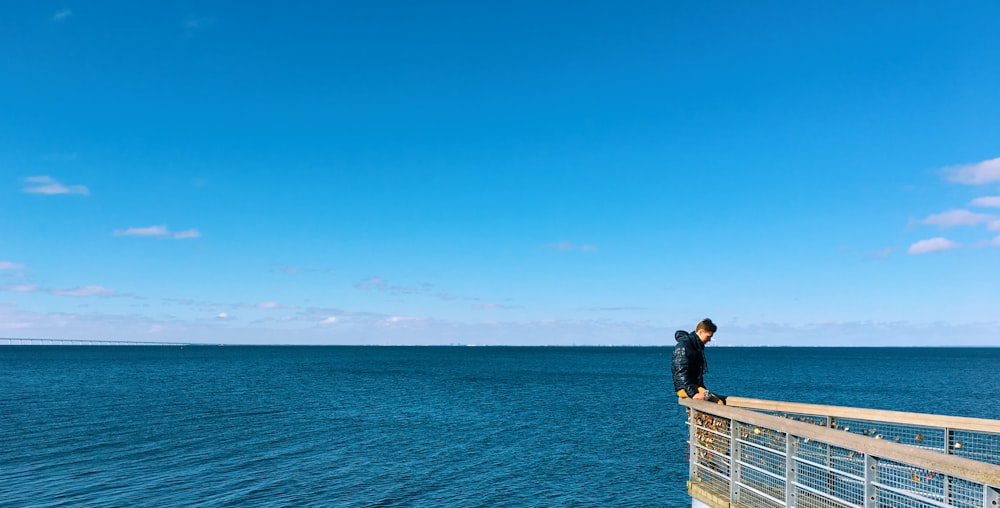 man sitting on a terrace overlooking the ocean