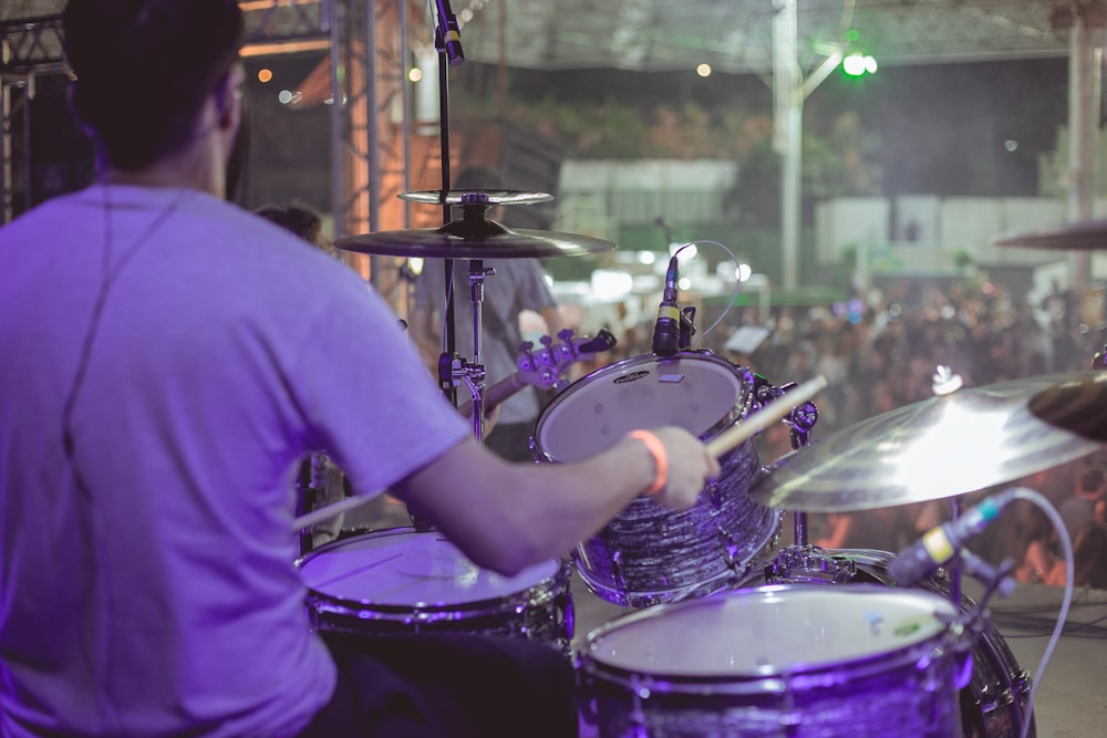 man playing drums infront of people