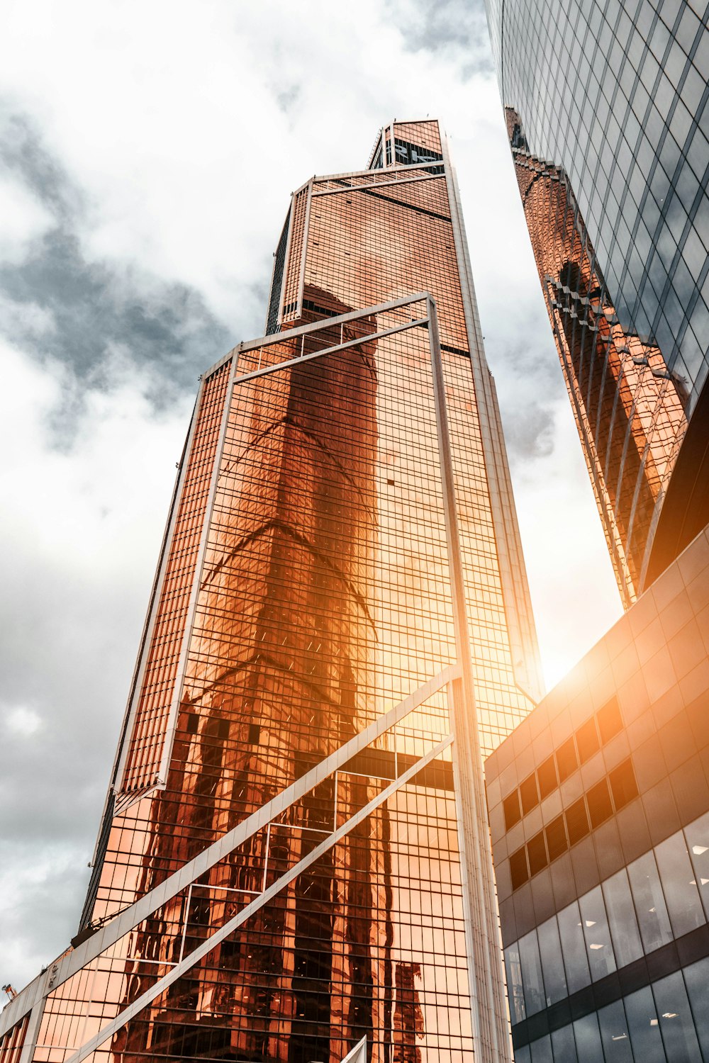 gold high-rise building under cloudy sky