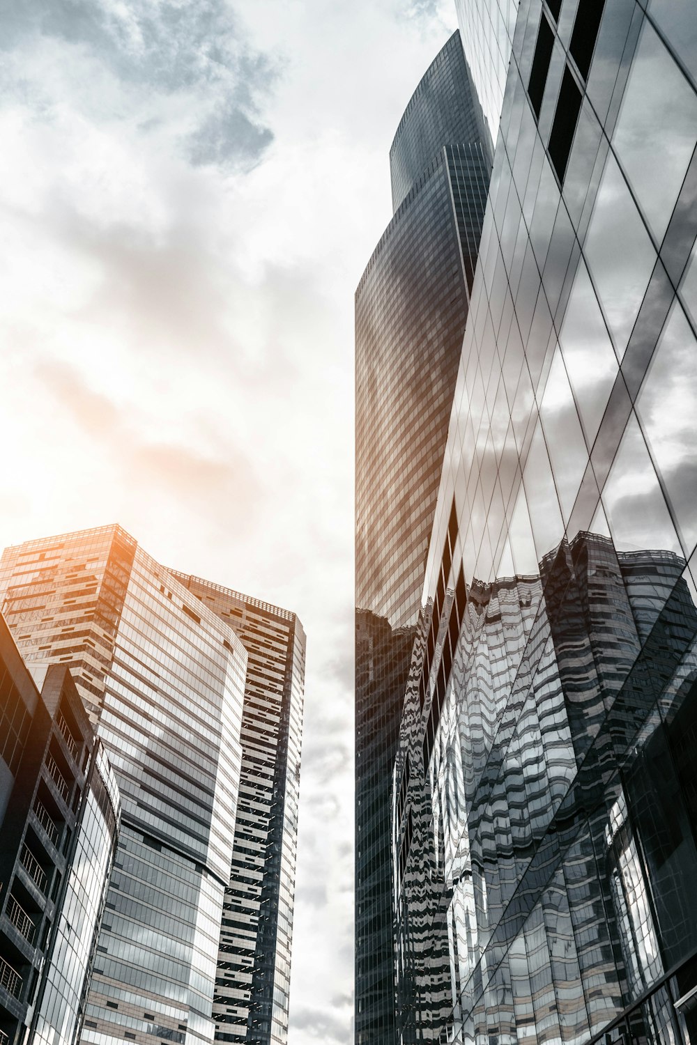 worm view photo of city buildings under cloudy sky