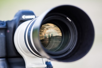 Close-up of a camera lens focusing on a vibrant cityscape at dusk.