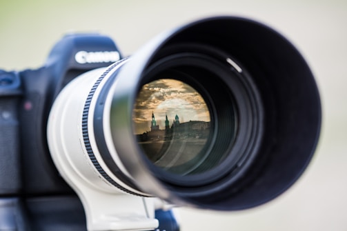 A close-up of a camera lens with reflections of a landscape.