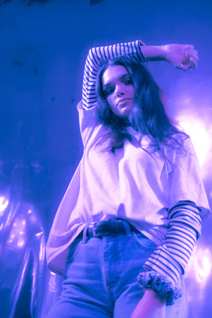 Close-up of a matte black oversized t-shirt with subtle electric purple glowing accents under moody lighting.