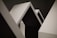 Geometric shapes with sharp angles and clean lines dominate the composition. The contrast between light and shadow highlights the minimalist design, featuring a series of triangular and rectangular forms.
