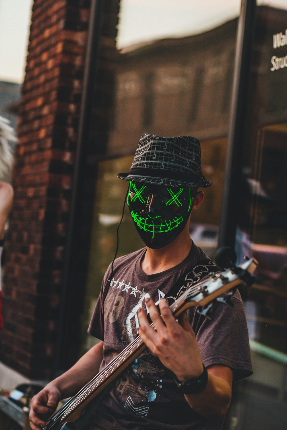person wearing black mask playing guitar