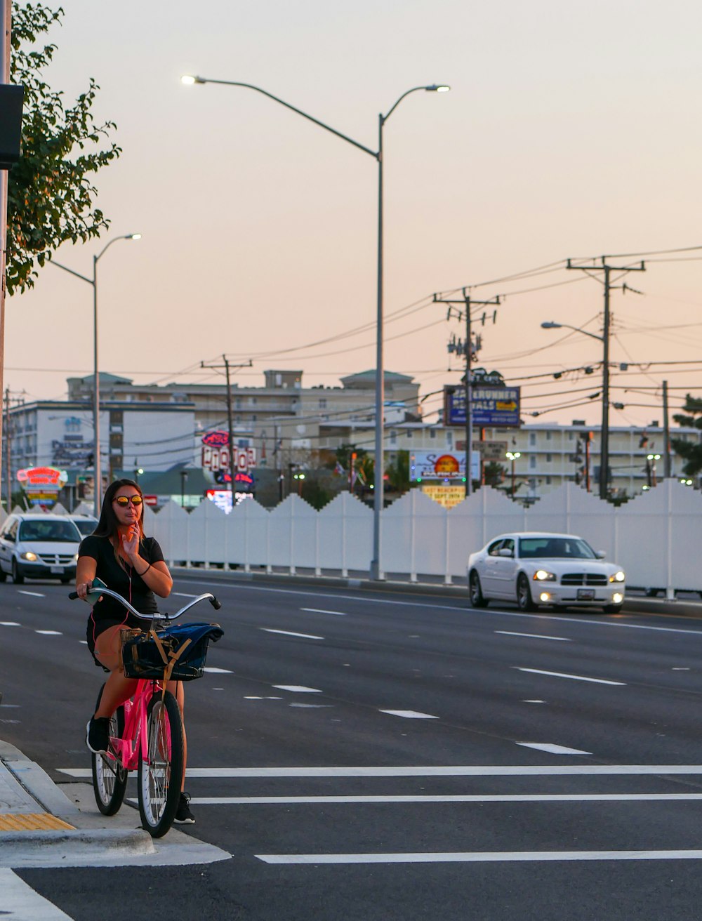 woman riding on bike beside road