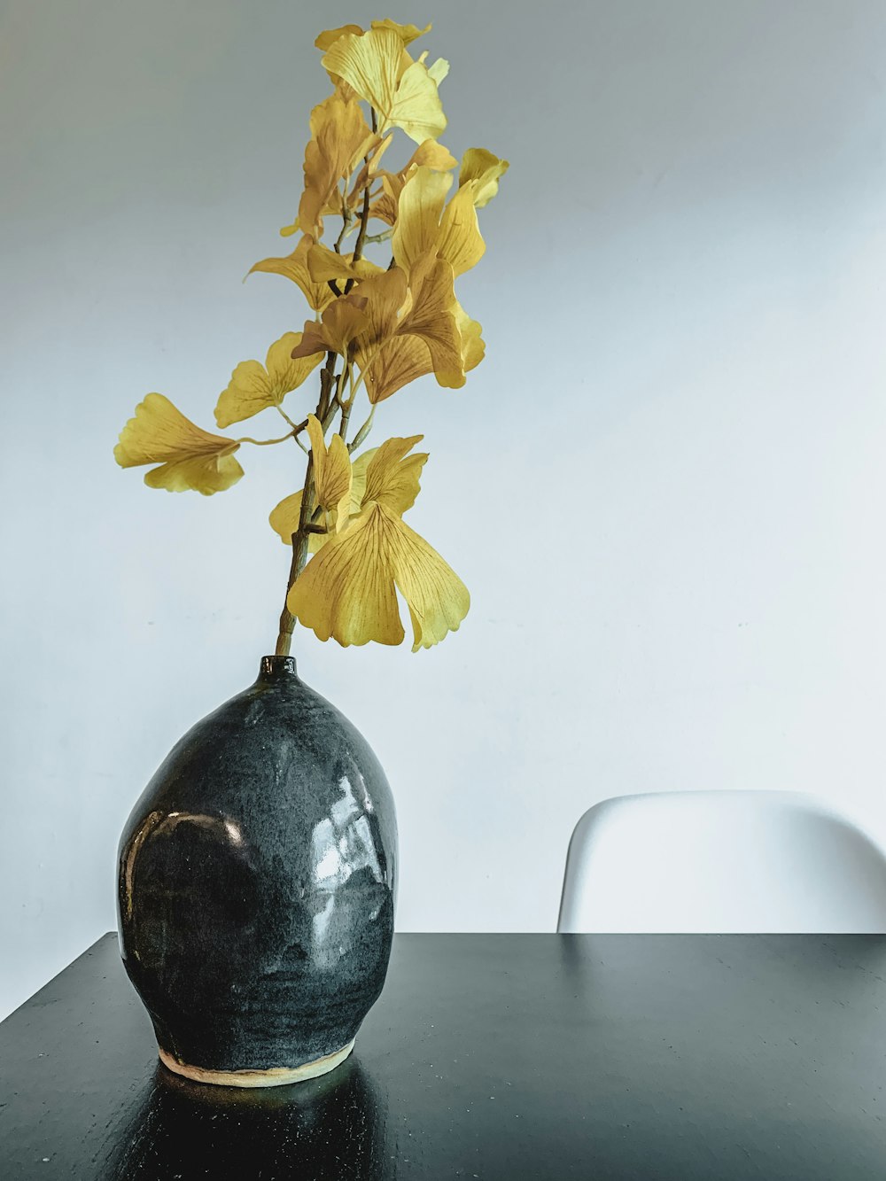 yellow flowers in gray vase