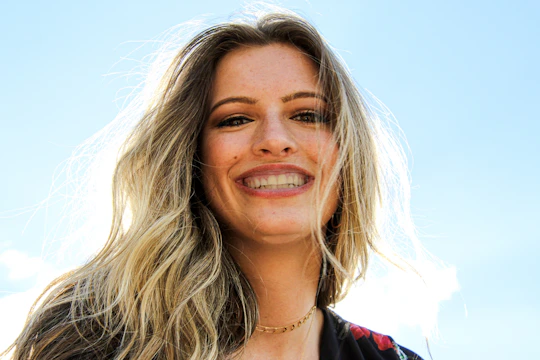 a woman with shiny, healthy hair smiling in natural light