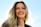 Smiling woman with shiny hair enjoying natural sunlight outdoors.