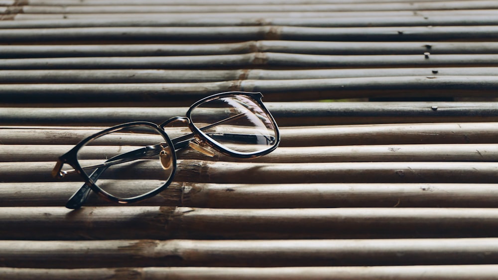 occhiali da vista con montatura nera su superficie in legno