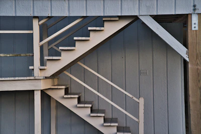 Exterior view of a custom-built staircase leading to a front porch with elegant railings.