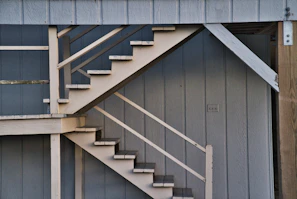 Exterior staircase with modern metal railings and natural wood steps blending into a landscaped garden