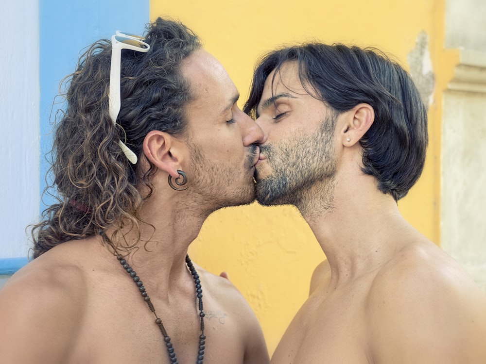 Due uomini con i capelli lunghi si baciano