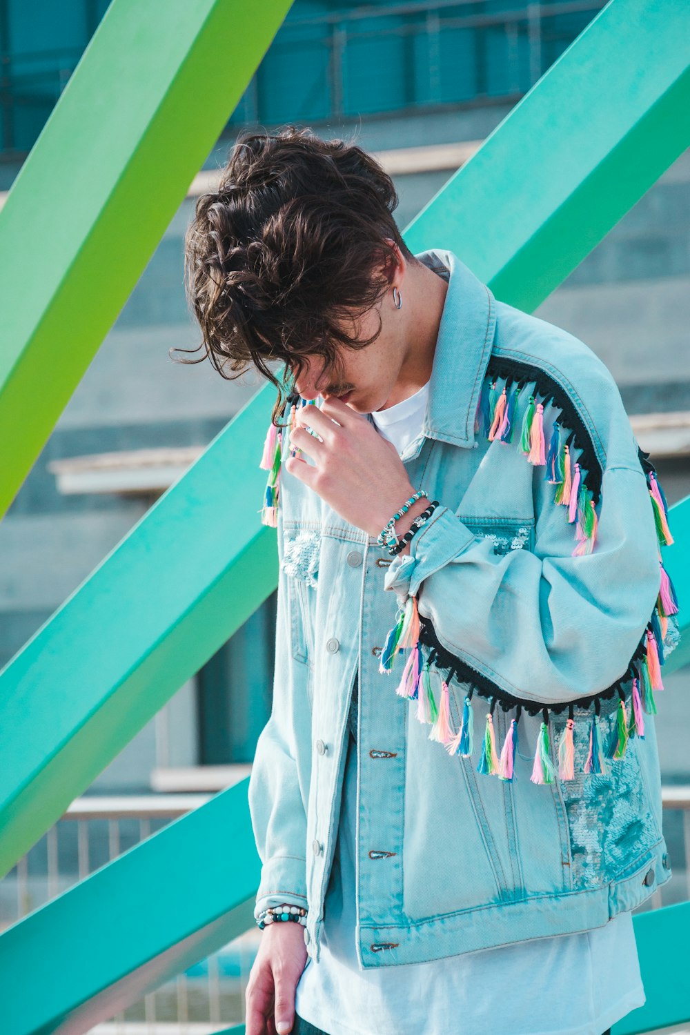 man wearing teal and black jacket and white crew-neck shirt