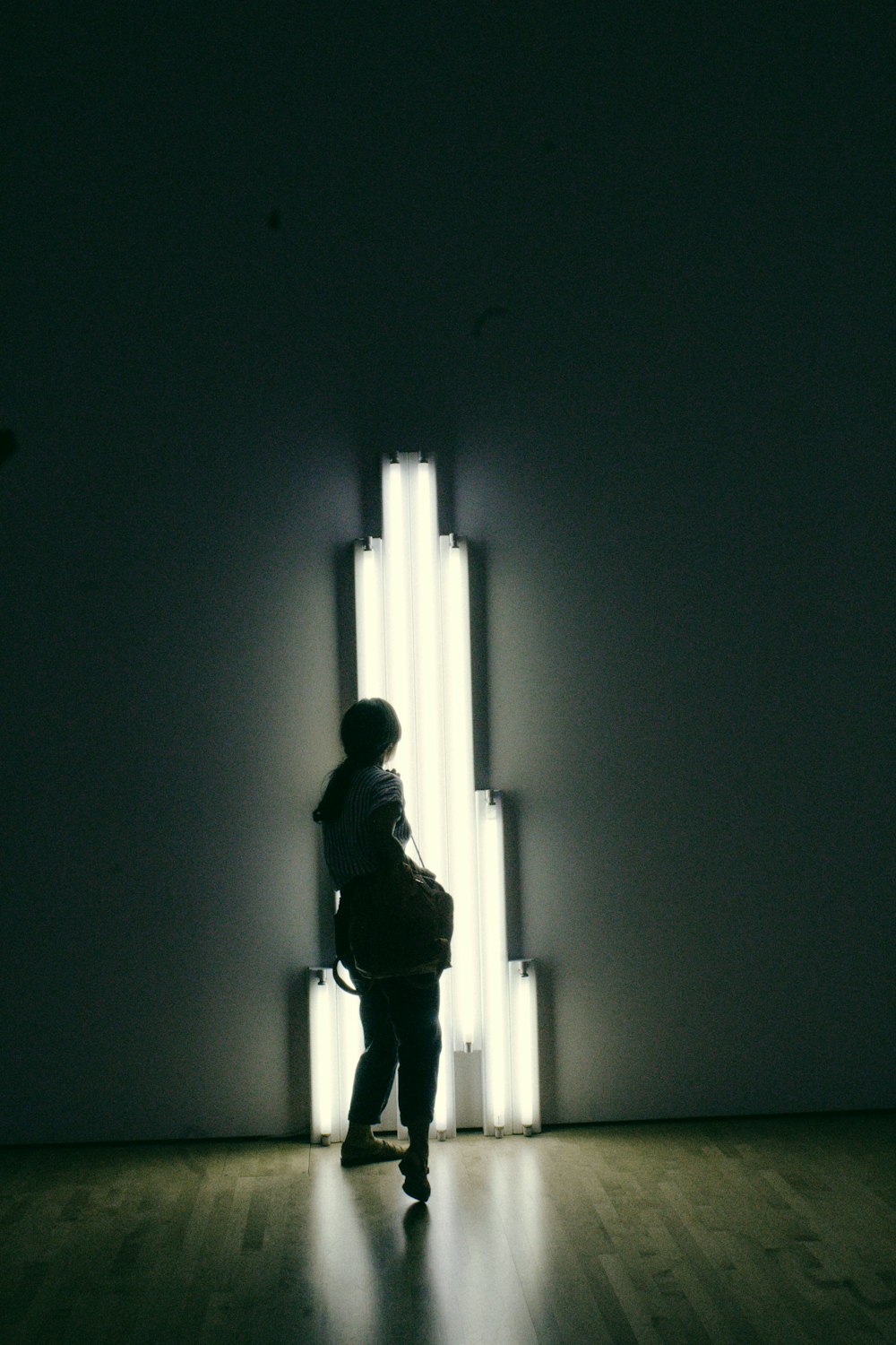 silhouette of woman looking at LED light