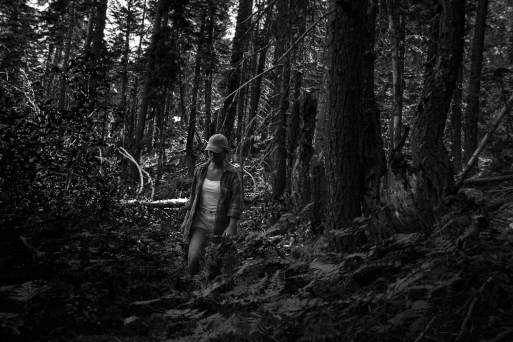 man walking beside trees