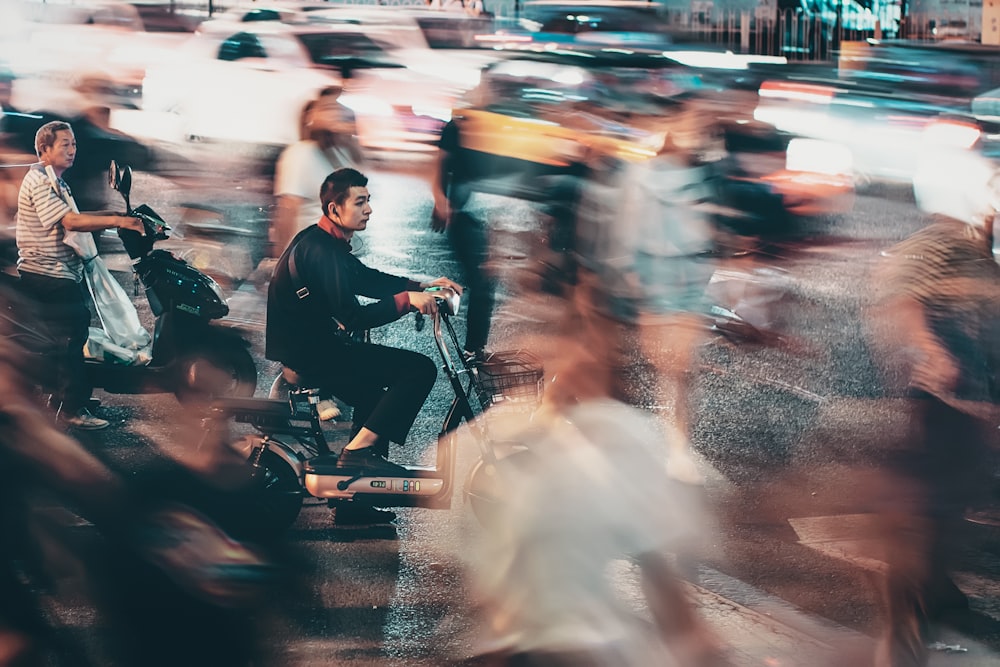 man riding scooter time lapse photo