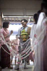 Family members from both sides smiling and preparing traditional gifts for the ceremony.
