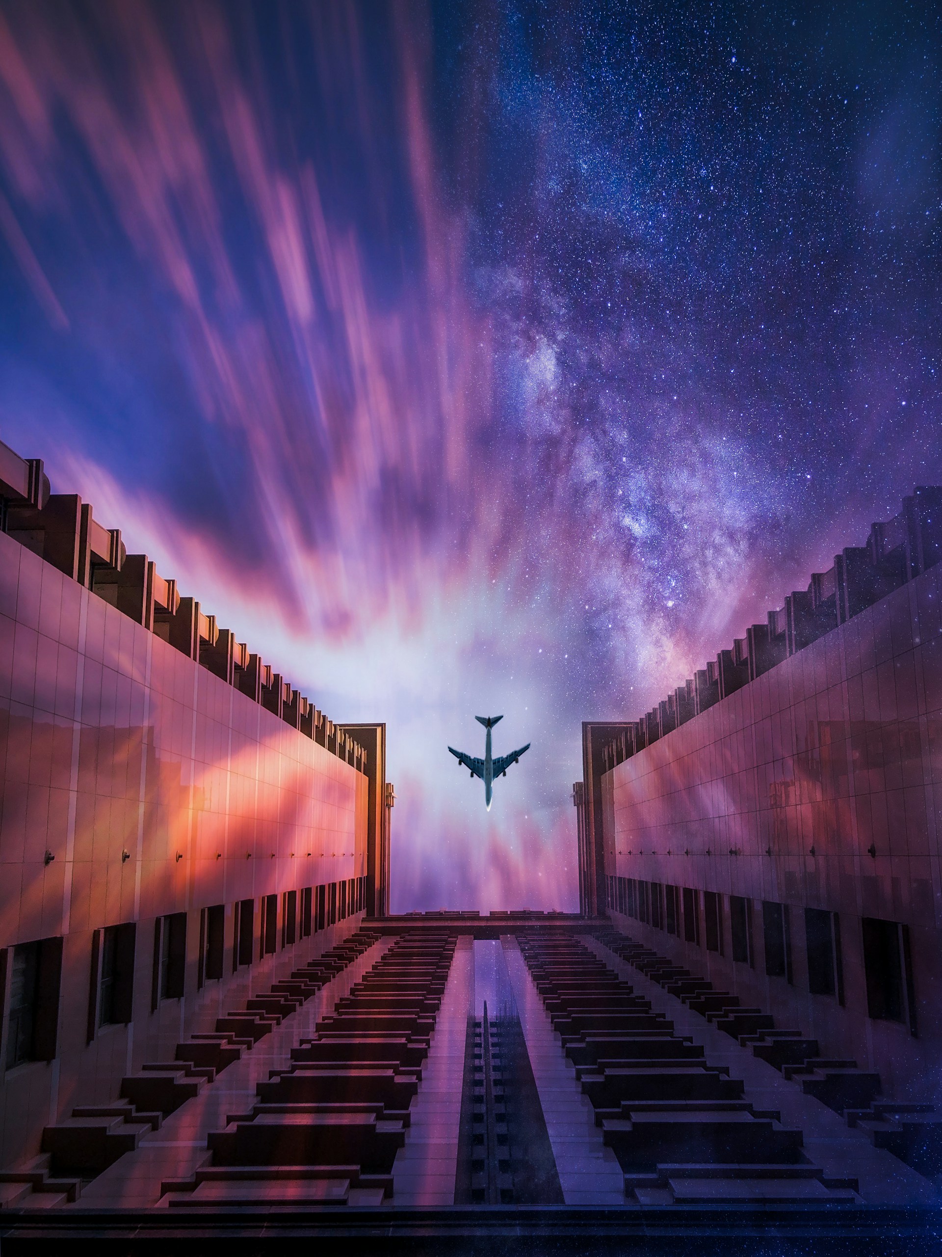 low-angle photograph of plane passing over concrete building