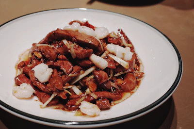 A beautifully plated Chinese stir-fry with fresh vegetables and seafood.