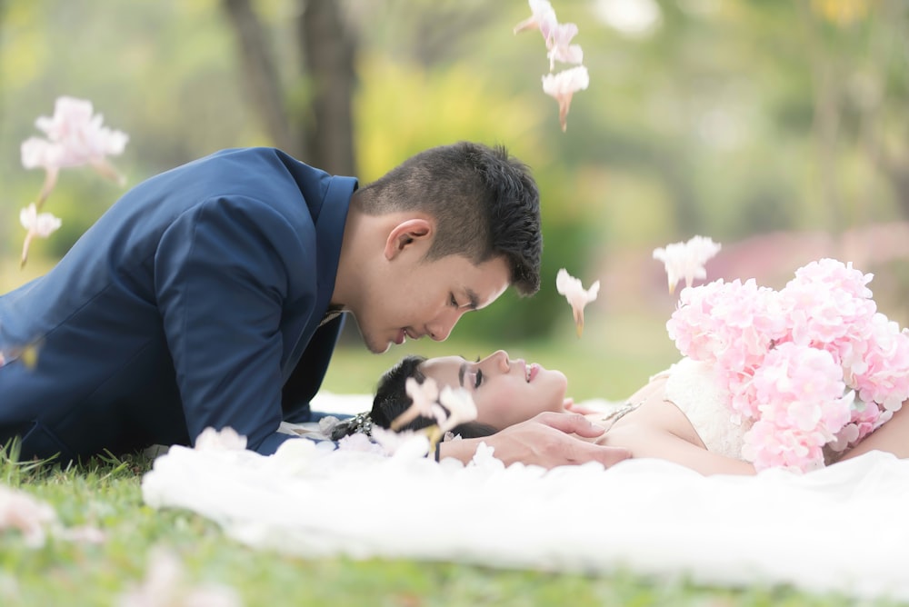 selective focus photography of man and woman lying on ground during daytime