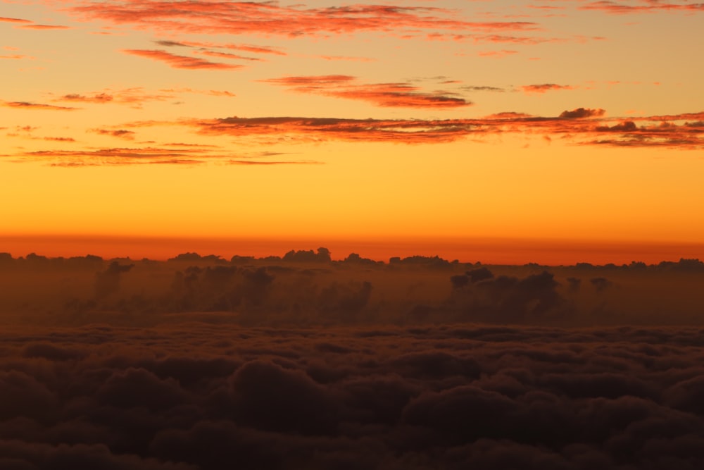 the sun is setting over the clouds in the sky