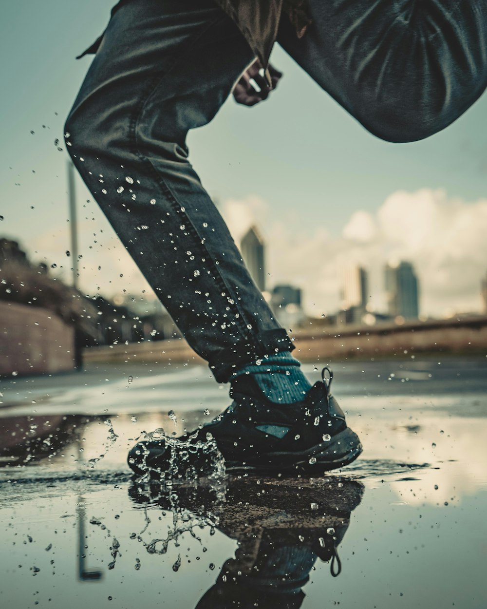 person wearing black shoe on surface with water