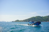 Dynamic shot of the fishing boat cutting through turquoise ocean waters under a clear blue sky.