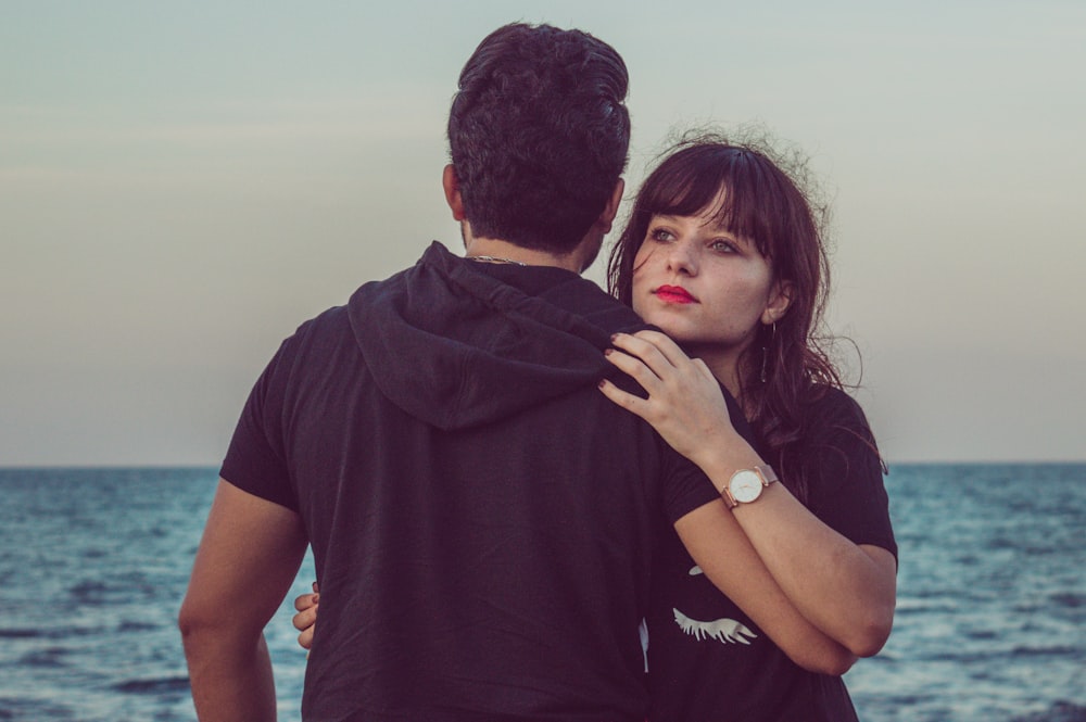 couple hugging beside sea