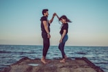A cinematic shot of a couple dancing barefoot on a beach during their pre-wedding shoot.