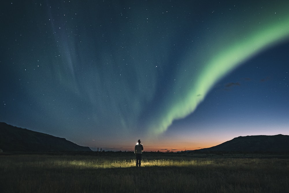 person standing on grass during night