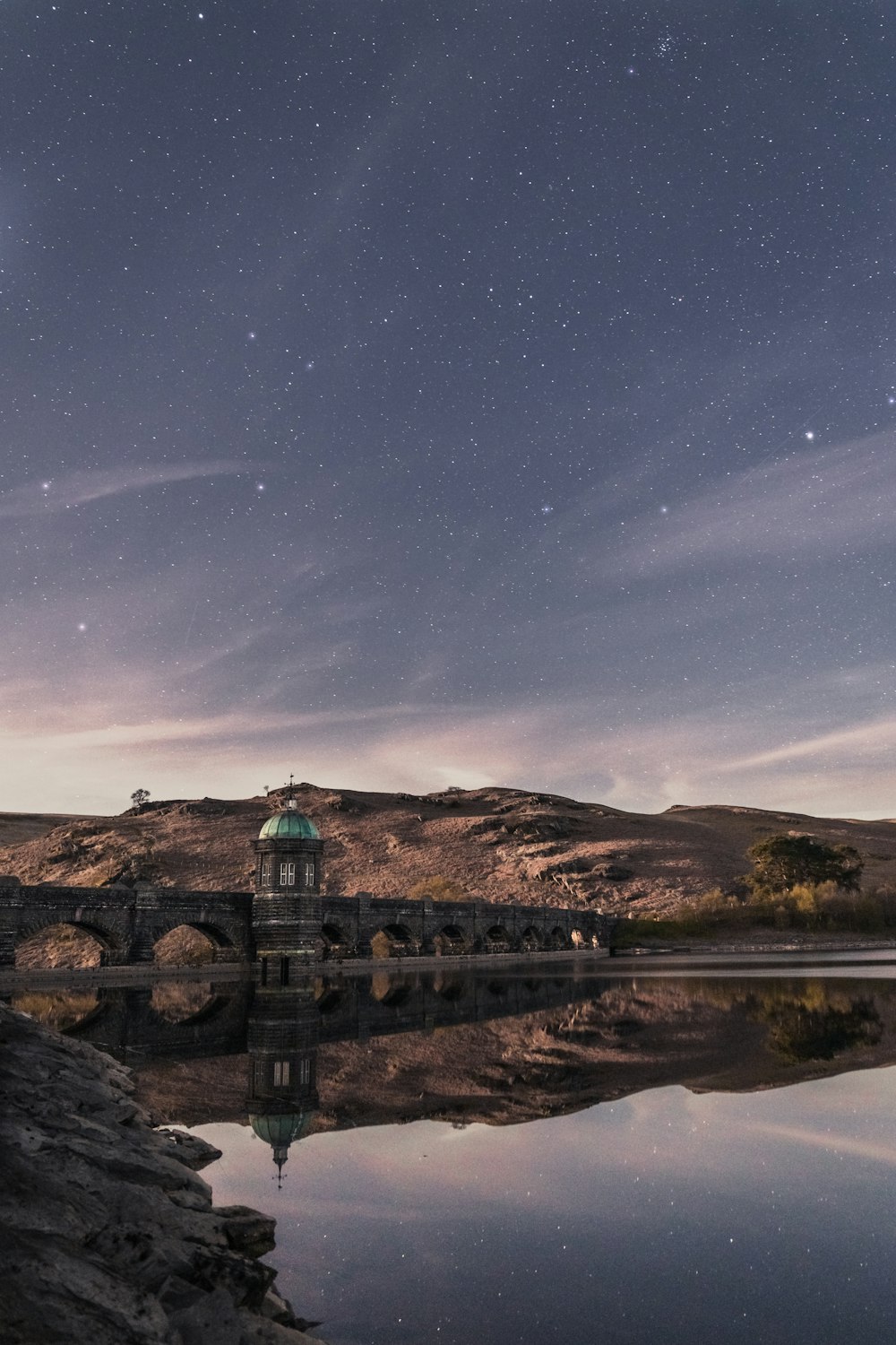 ruhiges Gewässer und Berge unter dem Sternenhimmel