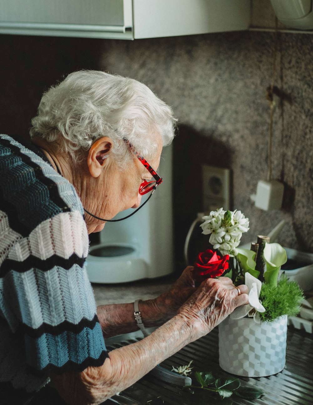 woman fixing flowers in pot