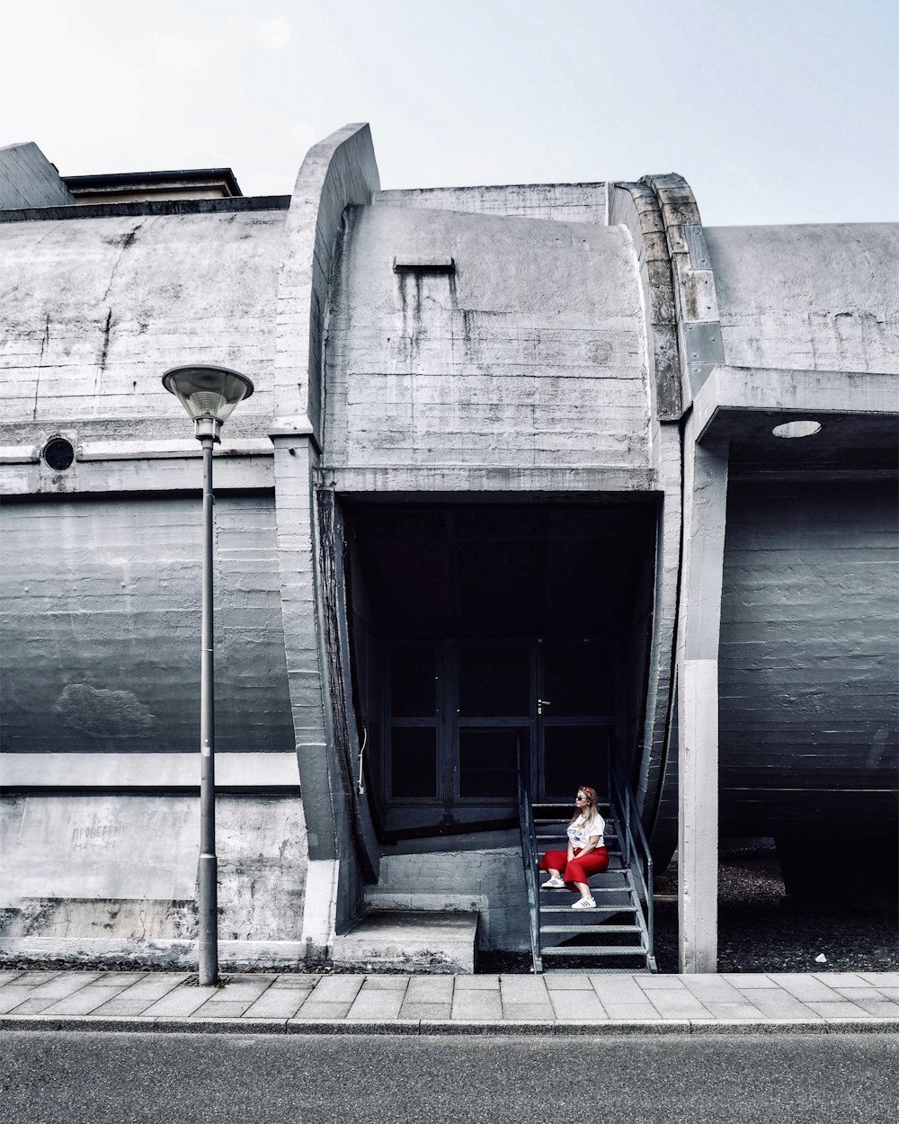 woman sitting on staircase near light post