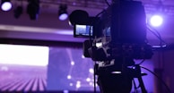 black video camera with tripod capturing stage