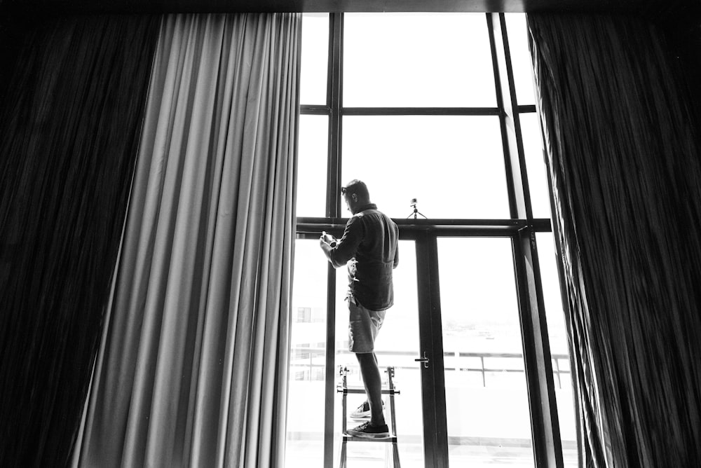 man standing beside window