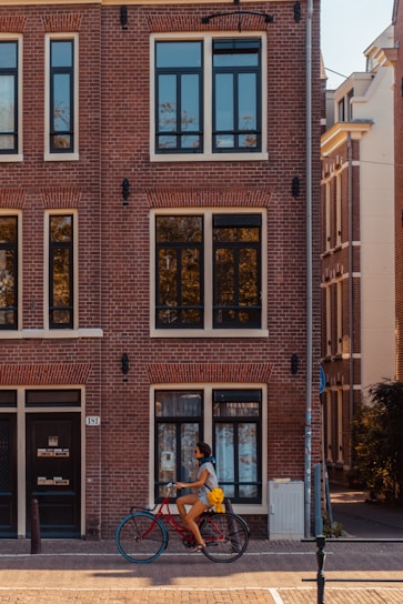 man riding bike in front of building during daytime