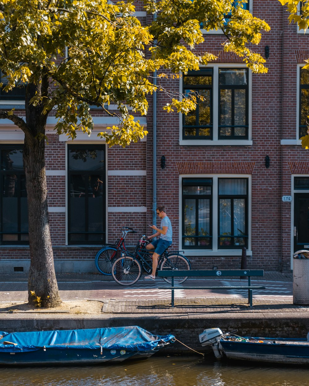 man riding bicycle beside building
