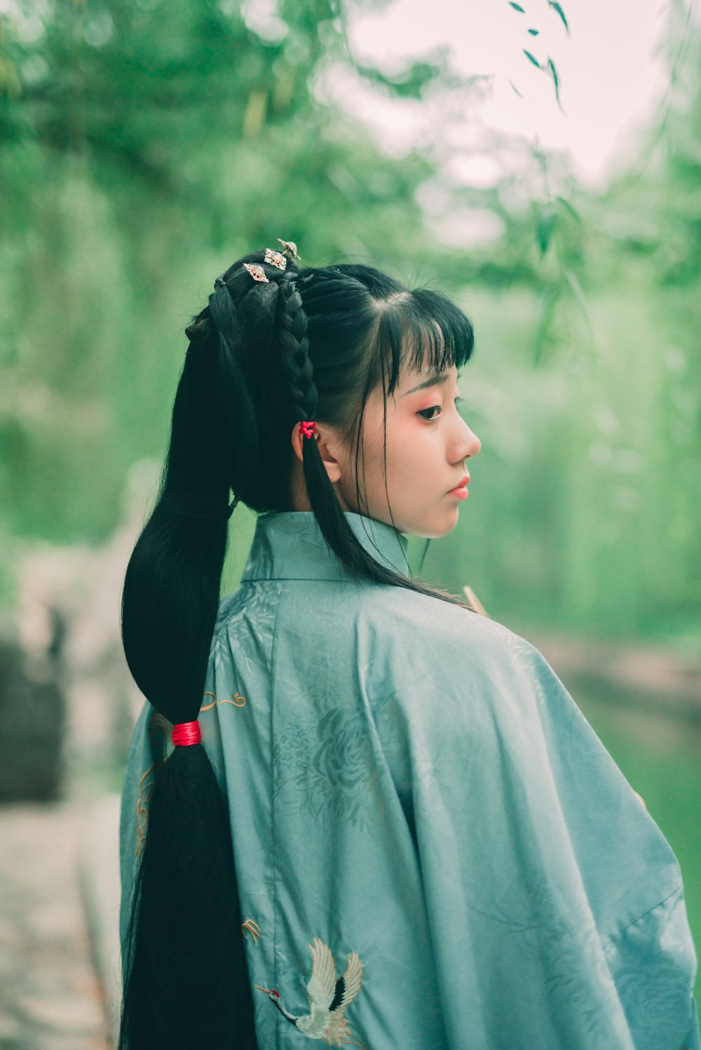 a woman in a blue kimono with a black ponytail