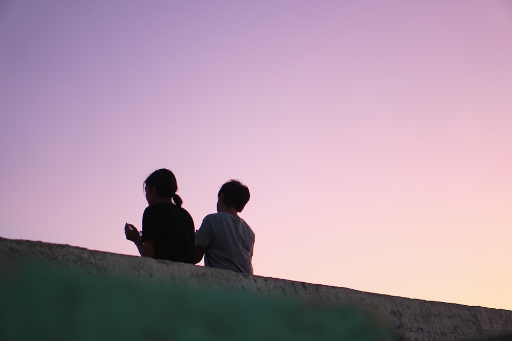 girl and boy lean on concrete hand rail