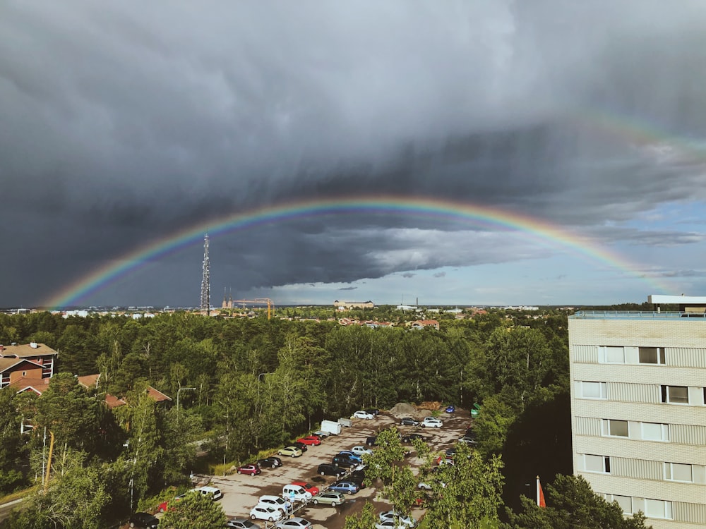 aerial photography of a rainbow over the city during daytime