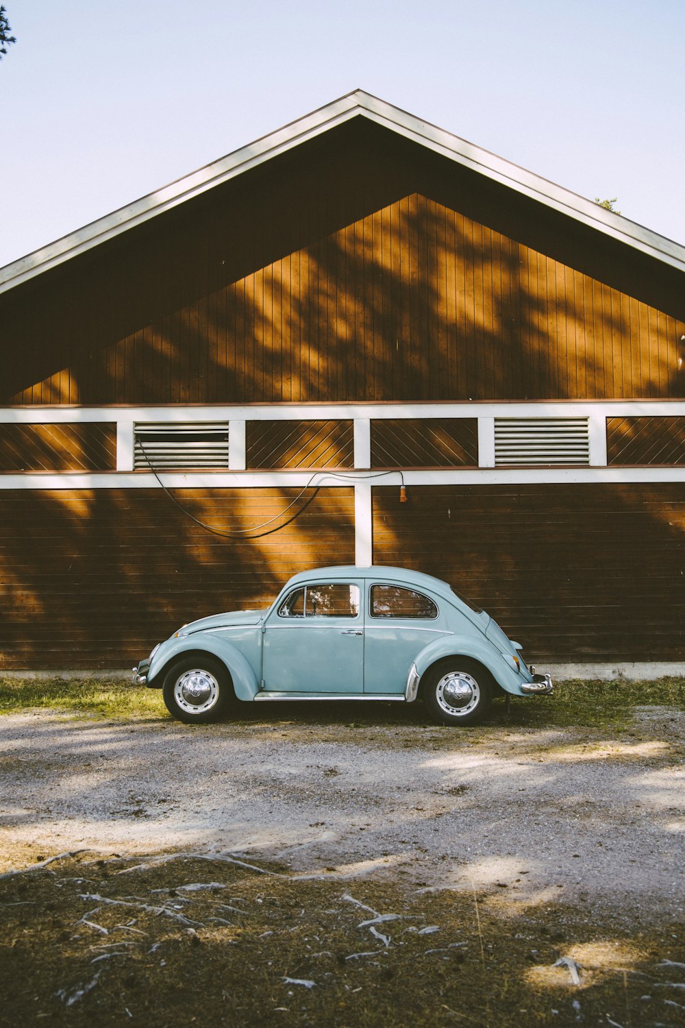 coupé blu Volkswagen Beetle accanto alla casa di legno