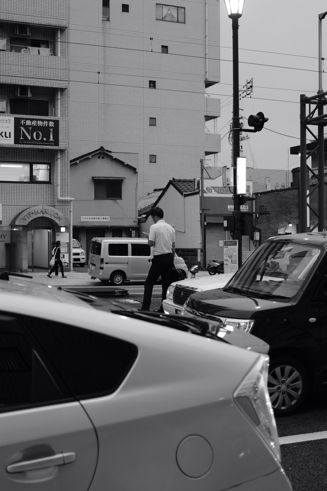 grayscale photography of man crossing the street
