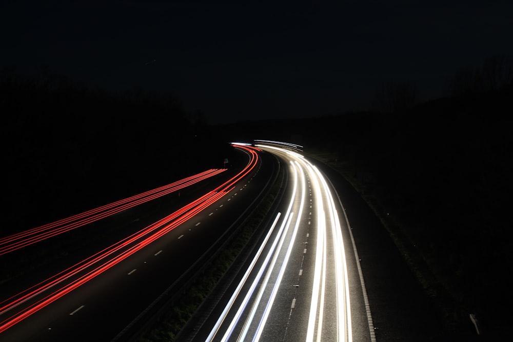 a long exposure photo of a highway at night