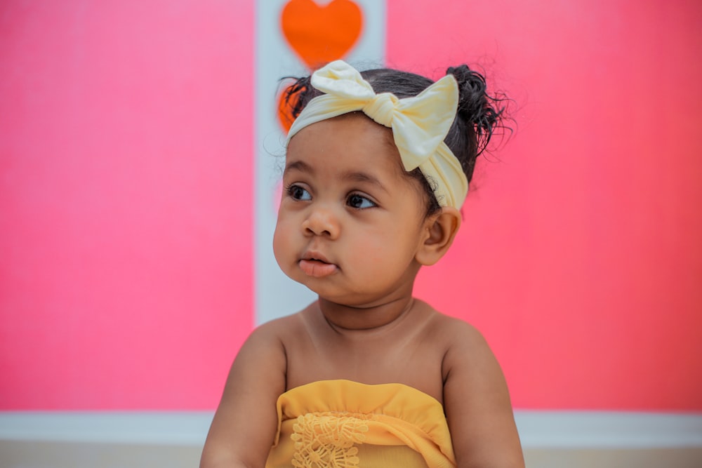 girl wearing yellow bow headband and tube top