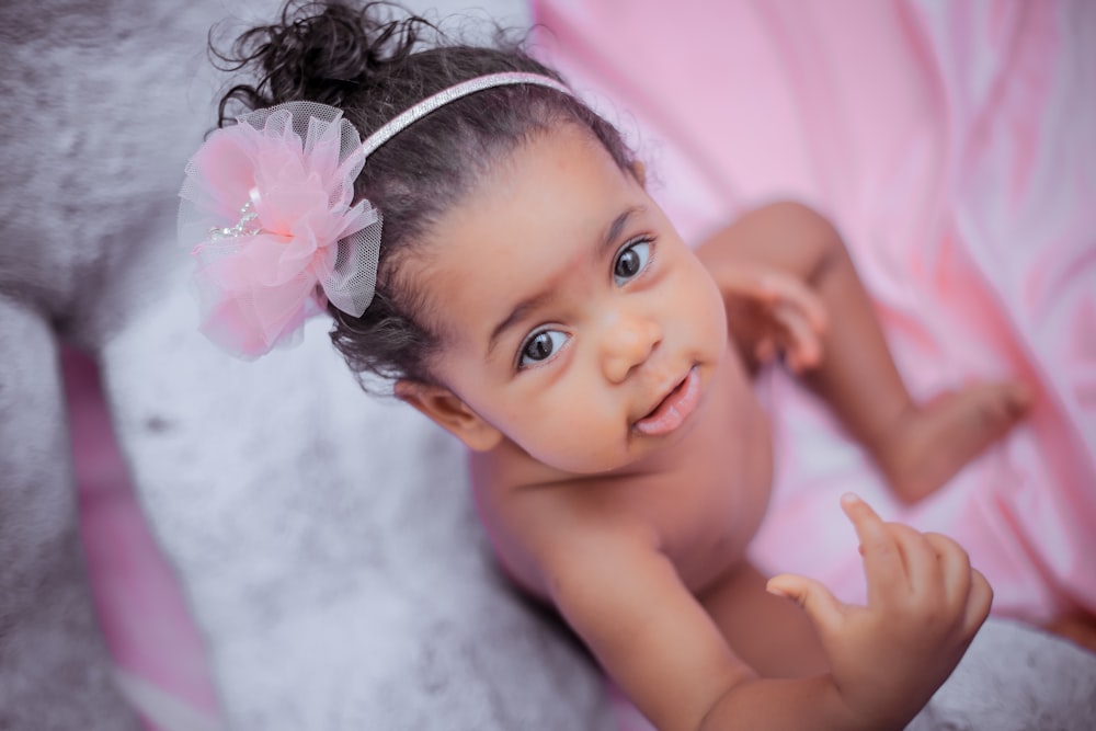 selective focus photo of girl wearing pink Alice band with flower accent