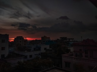 A cinematic shot of a cityscape at dusk with glowing red and black tones.