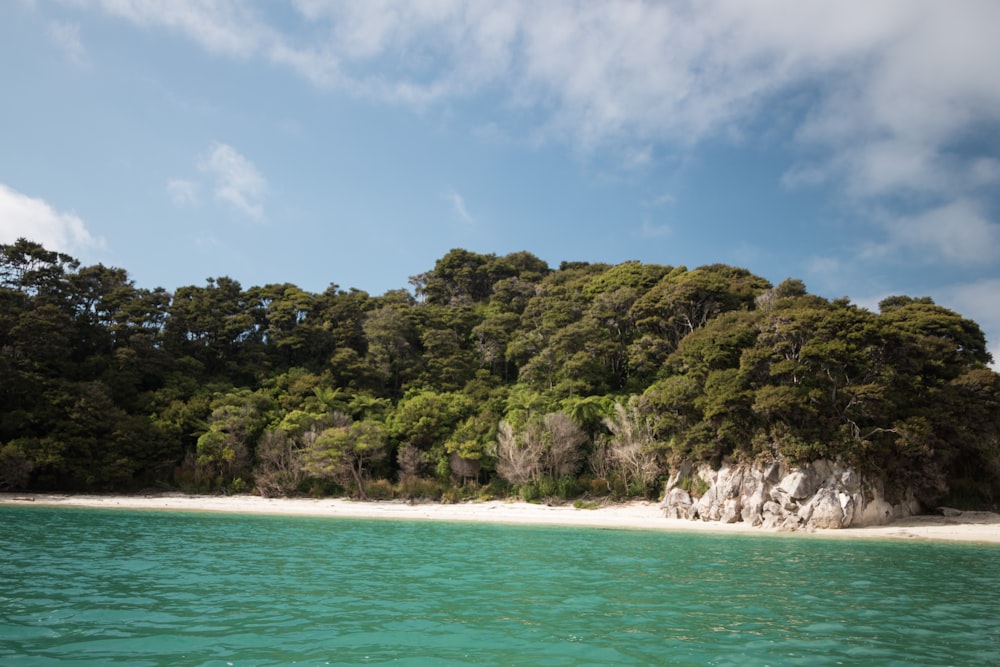 sea viewing mountain under blue and white skies during daytime