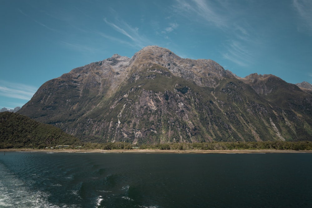 brown mountain beside body of water